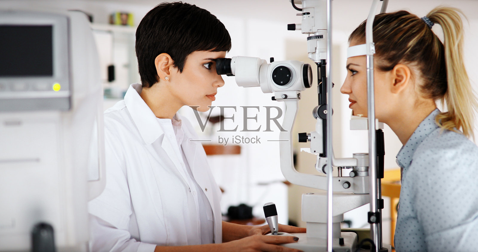验光师检查病人的视力和矫正视力照片摄影图片