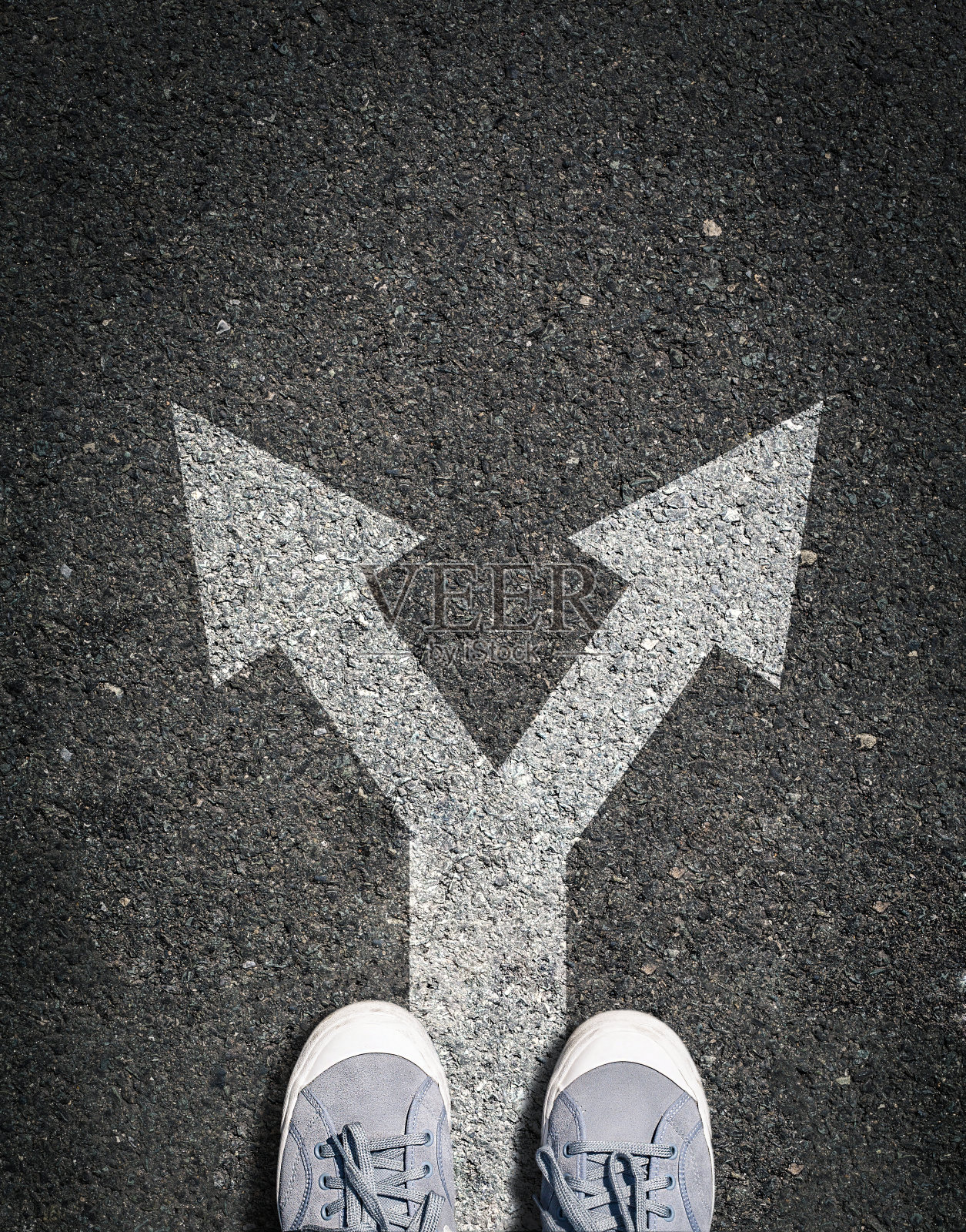 鞋在柏油路上有两个方向标志，概念是做选择和做决定照片摄影图片