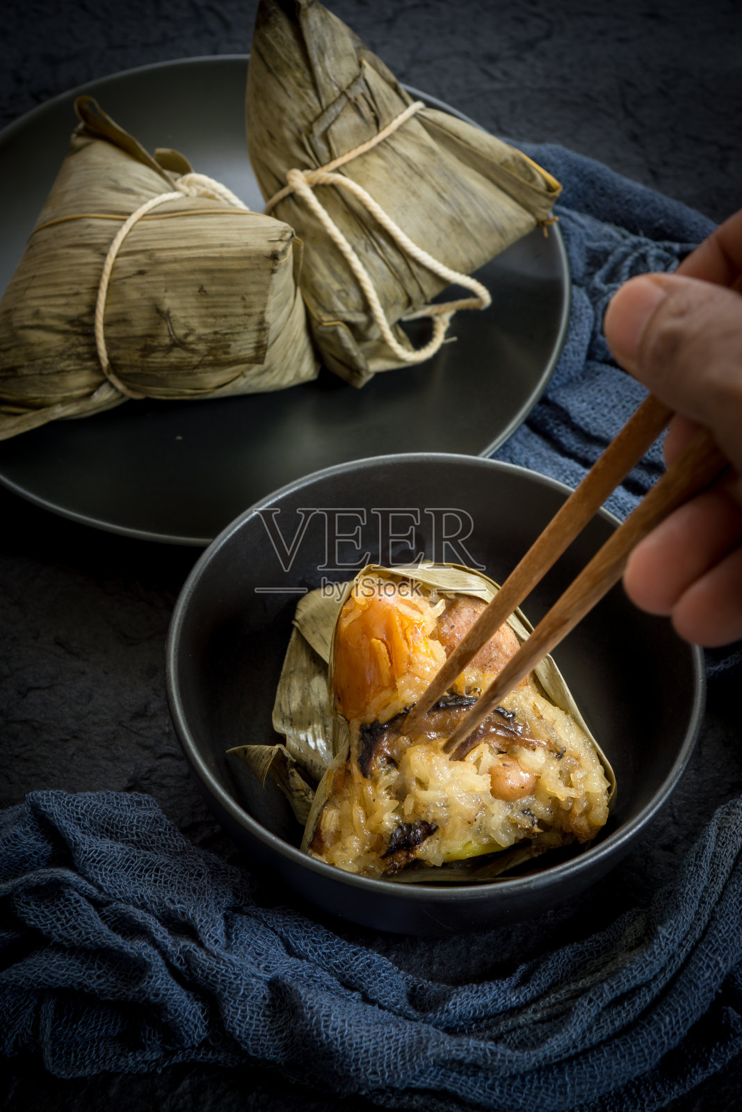 端午节吃粽子或中国传统的糯米团子照片摄影图片