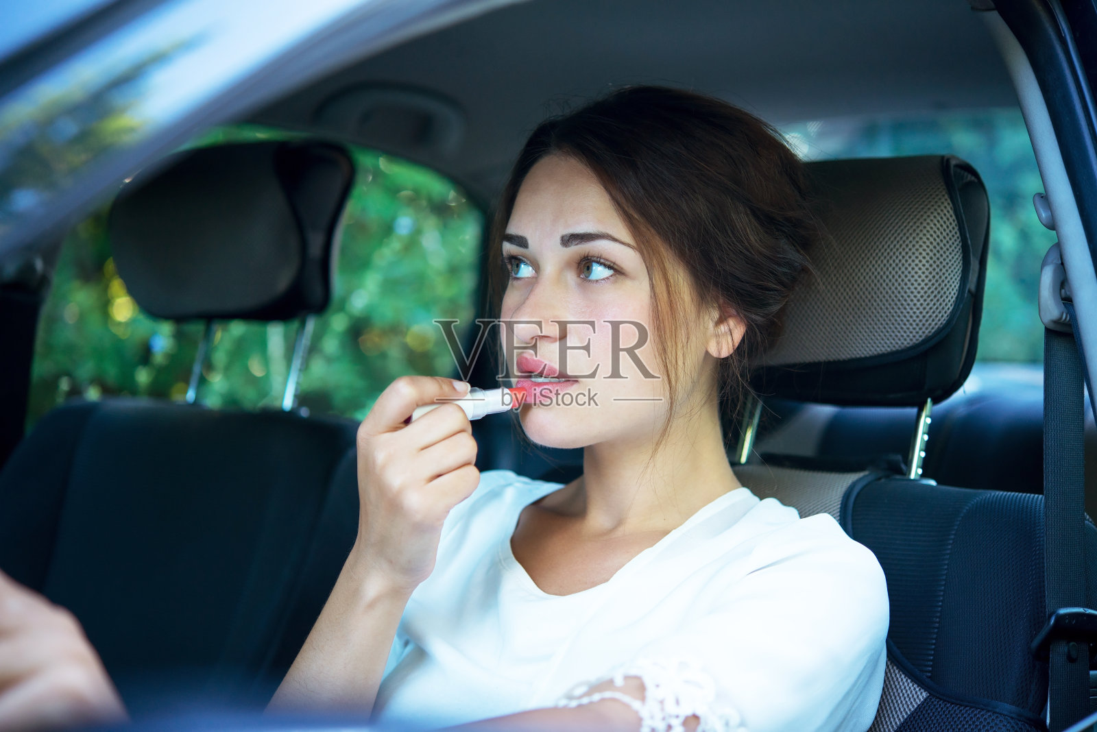 涂着口红的女孩开车时照镜子照片摄影图片