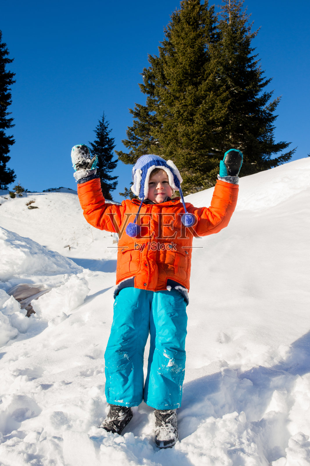 男孩在雪坡上玩耍。照片摄影图片