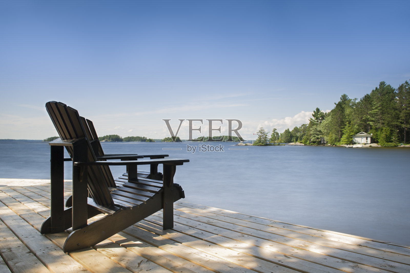 阿迪朗达克的椅子面对着一个平静的湖照片摄影图片