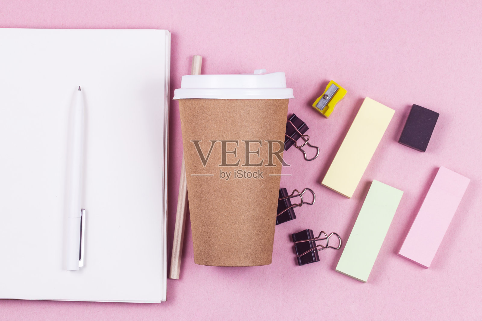 学生书包内物品。键盘，笔记本，文具，咖啡杯在粉红色的背景俯视图拷贝空间照片摄影图片