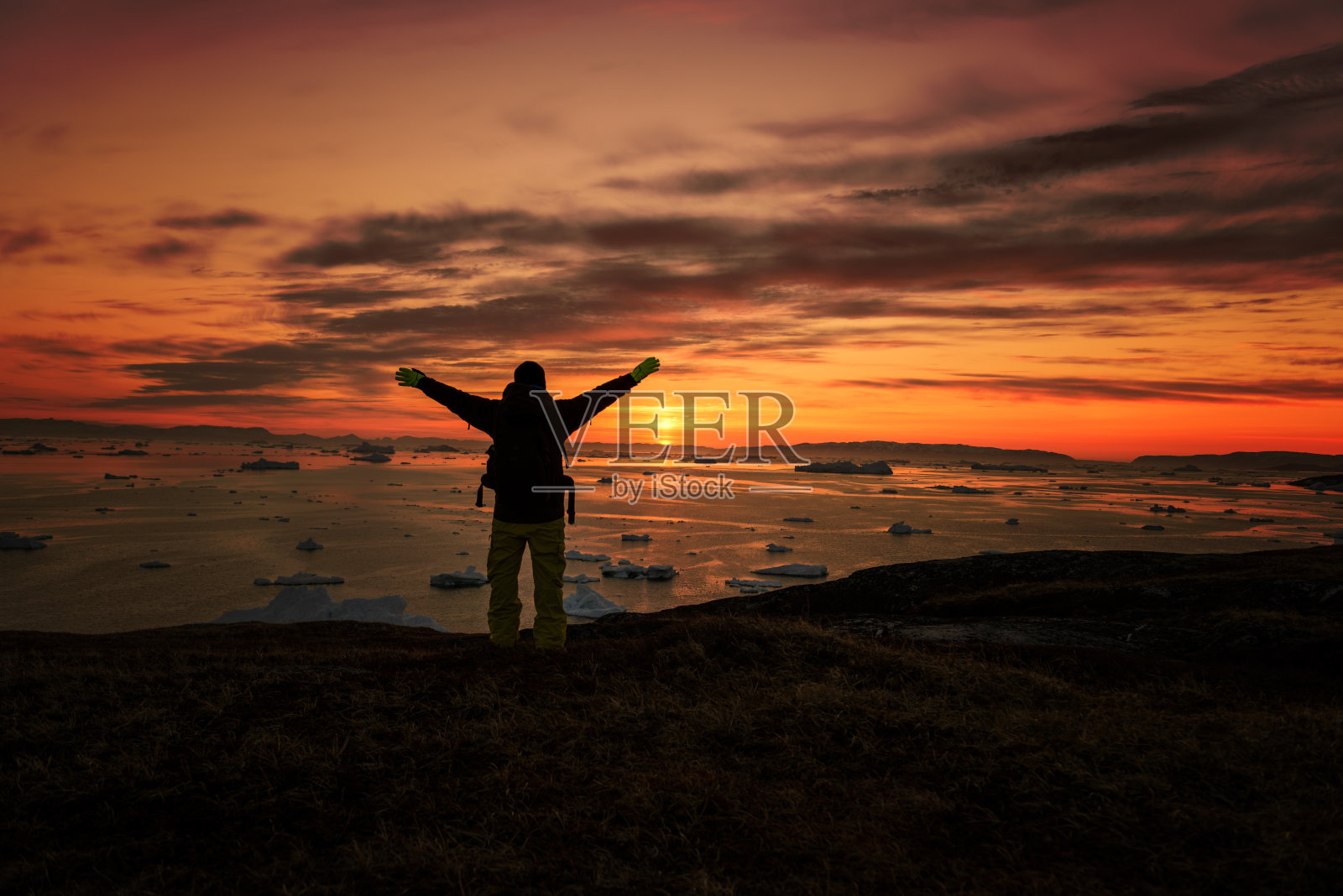 格陵兰岛，人们在日落时在北冰洋上剪影照片摄影图片