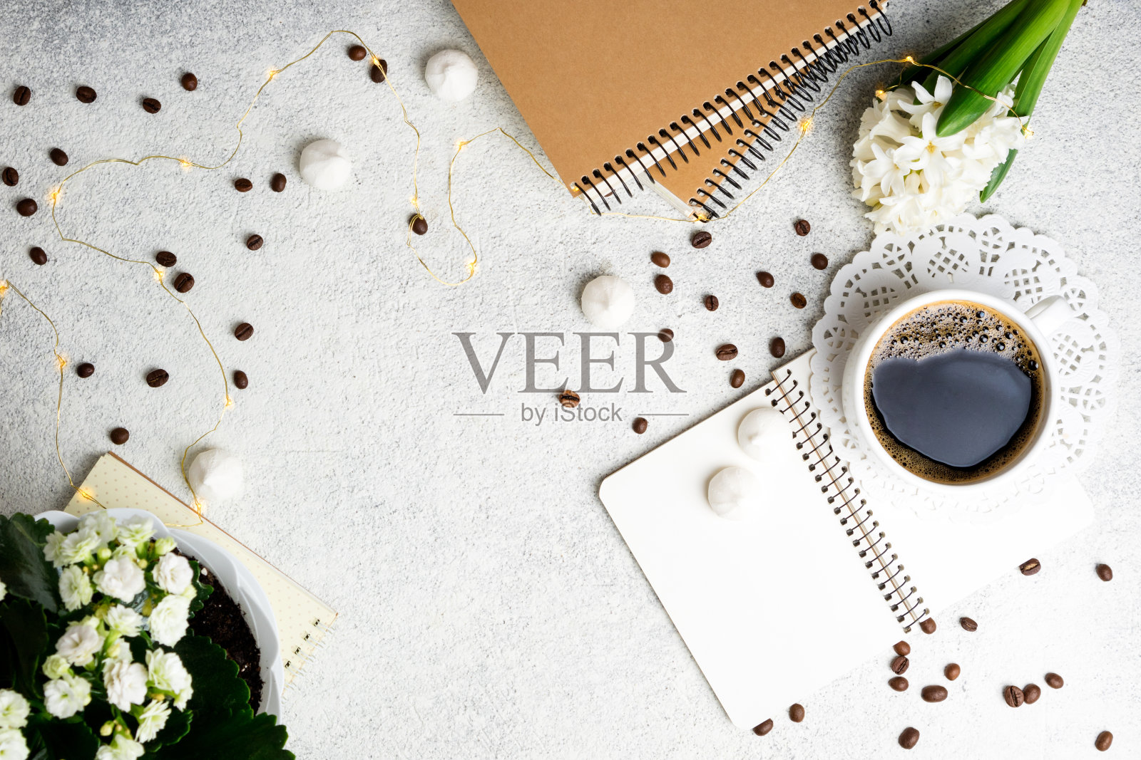 白色背景上的咖啡杯和家居装饰。咖啡，鲜花，笔记本和led灯，舒适的周末概念，俯视图照片摄影图片