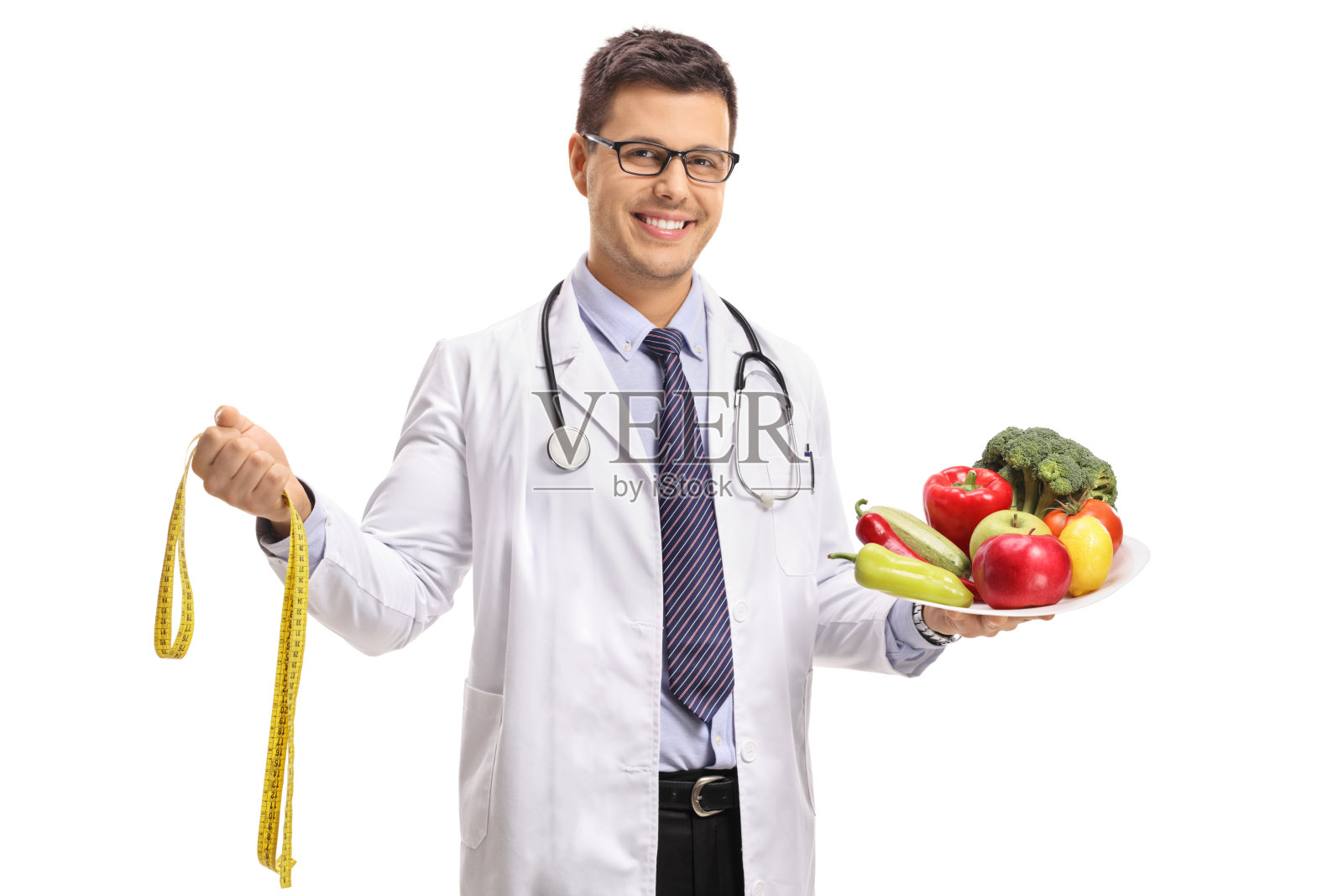 医生用一根卷尺和一个装着蔬菜和水果的盘子照片摄影图片