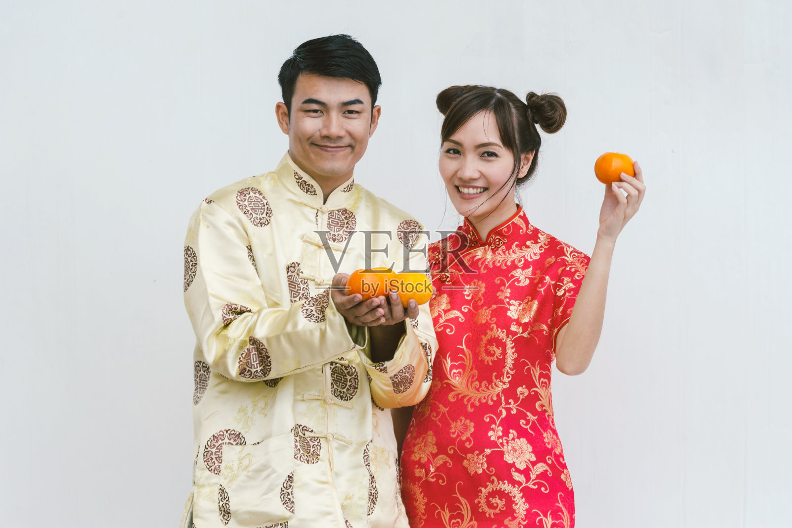 快乐的年轻夫妇拿着橘子。中国新年。照片摄影图片