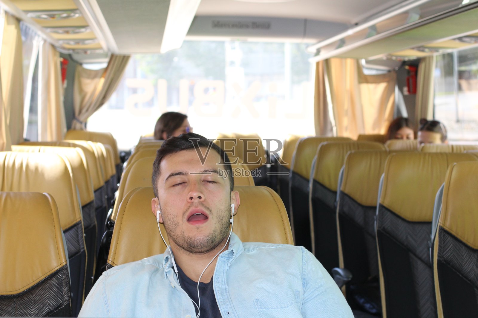 男性在巴士旅行中舒适地睡觉照片摄影图片