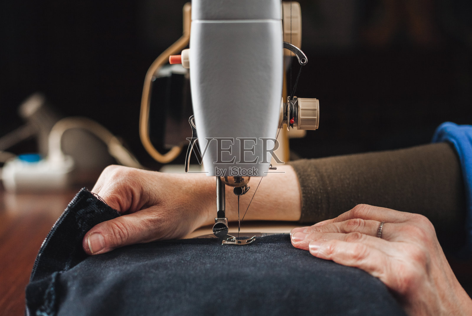 女性的双手在缝纫机上工作照片摄影图片