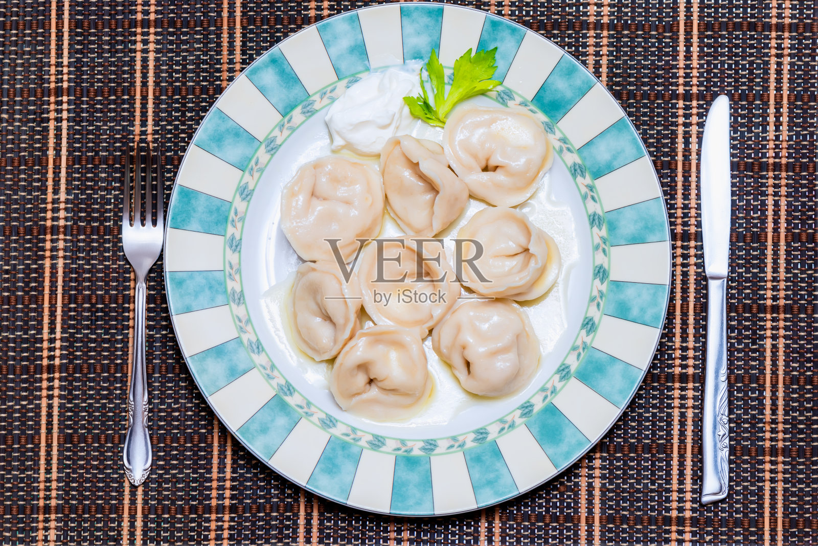 开胃的水饺与酸奶油在一个大漂亮的盘子照片摄影图片