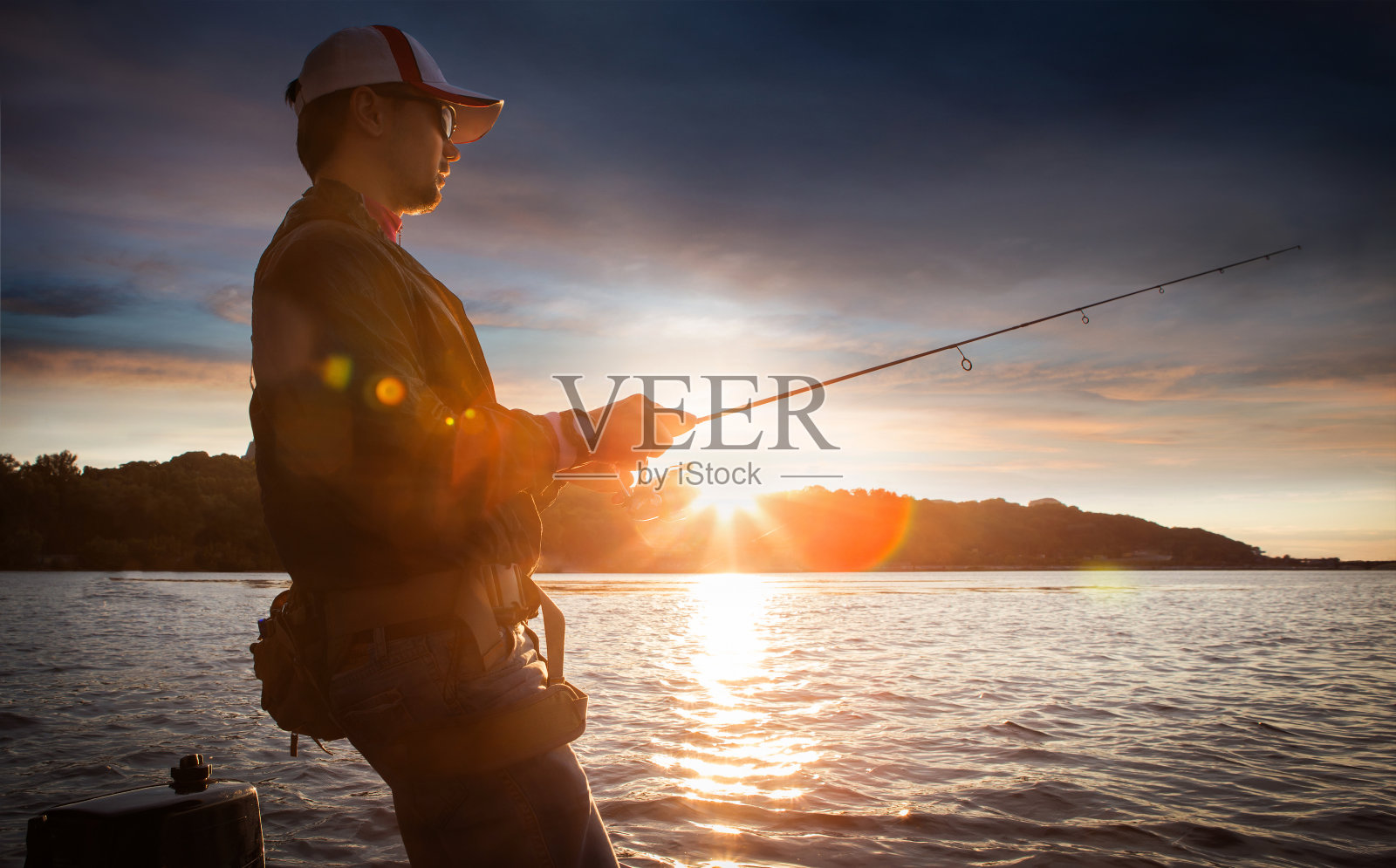 钓鱼。一个人在湖边钓鱼。日落照片摄影图片