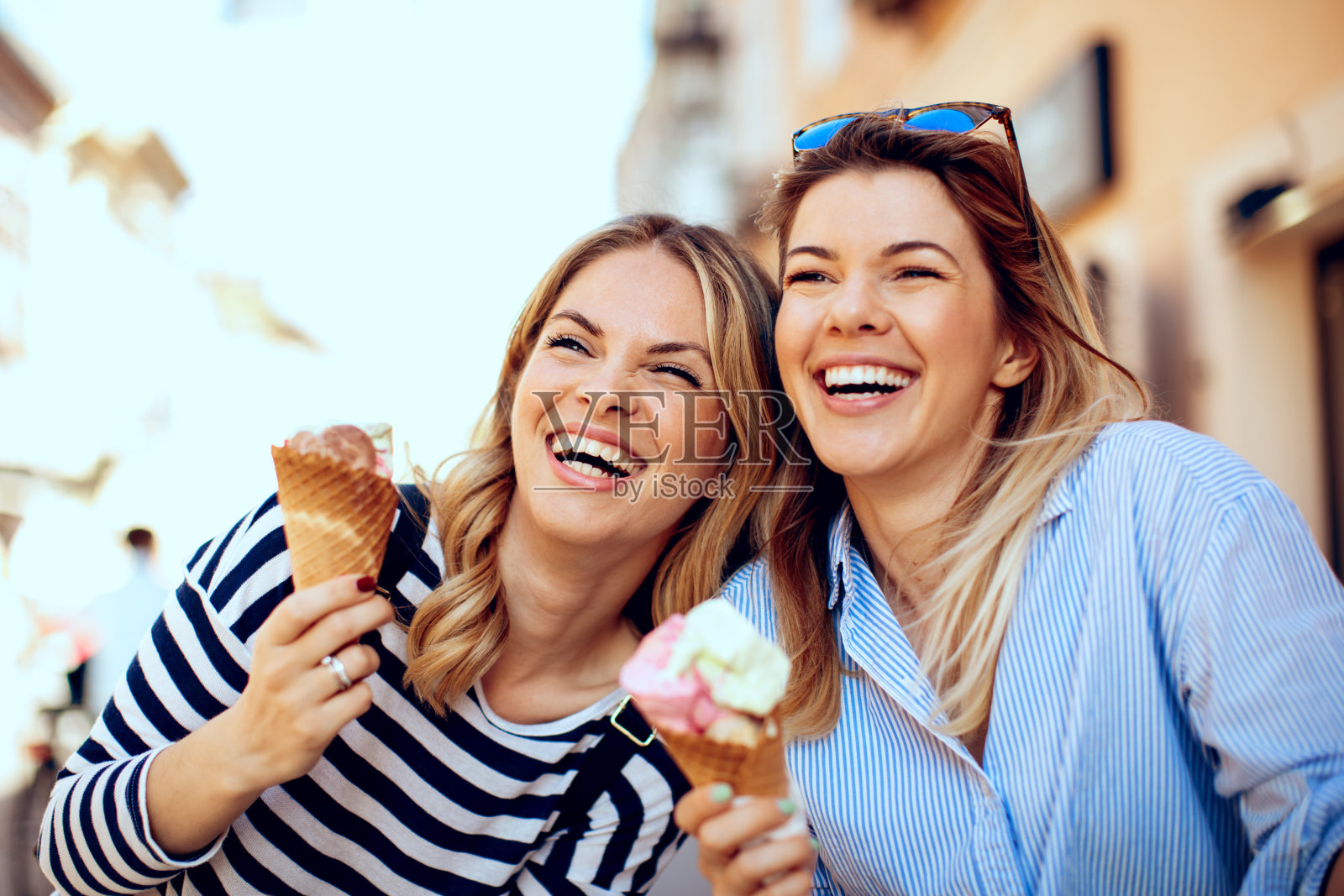 两个年轻的女人笑着手里拿着冰淇淋照片摄影图片
