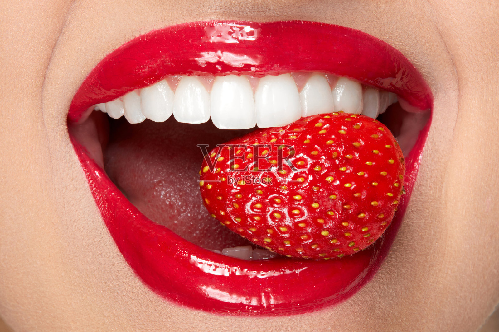 嘴唇。涂着红唇和草莓的女人照片摄影图片