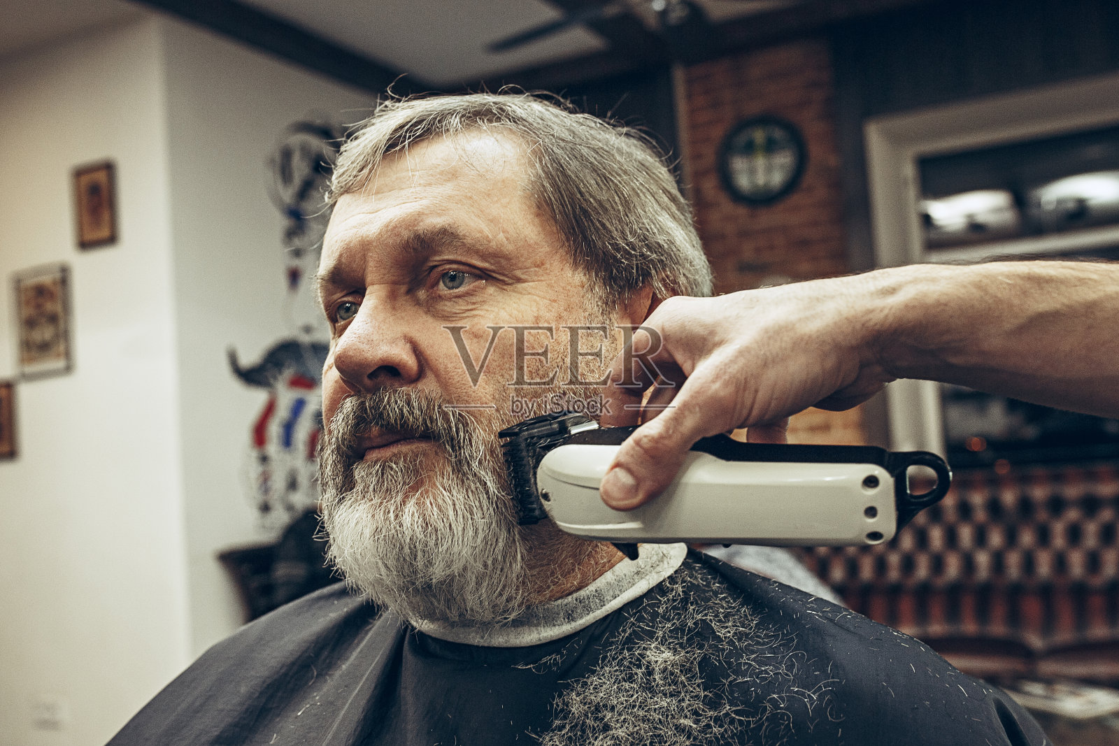 特写侧视图肖像英俊的资深胡须白种人得到胡子美容在现代理发店照片摄影图片