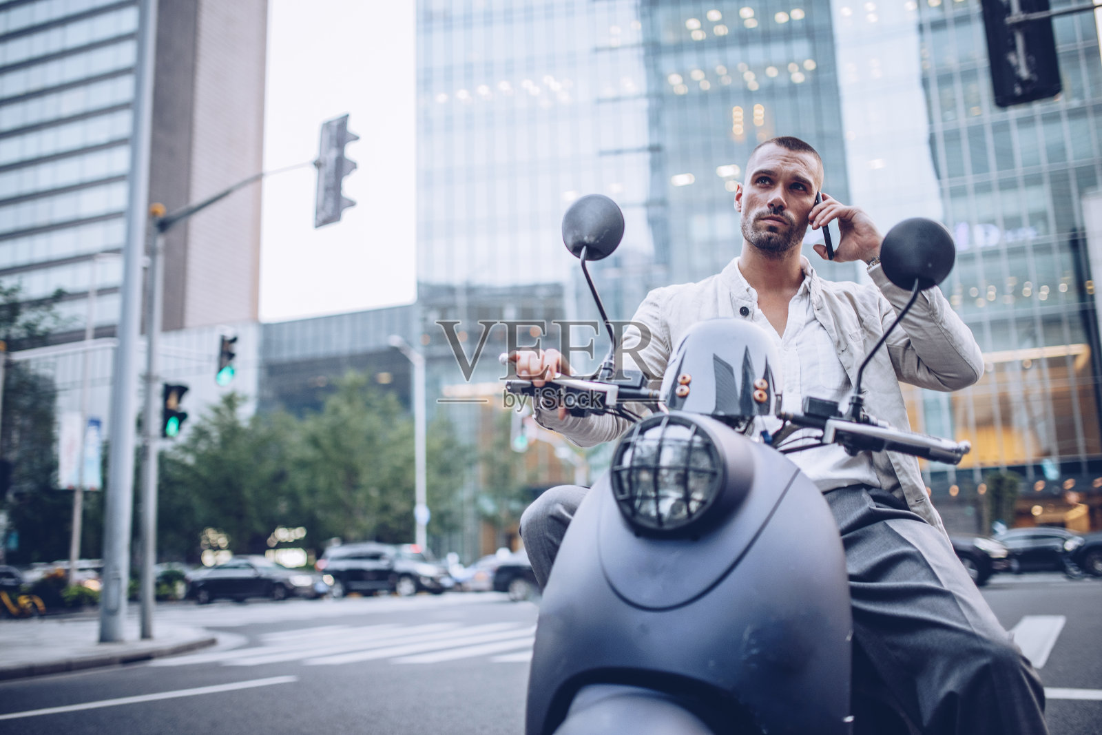 一个骑着摩托车，带着手机的男人照片摄影图片