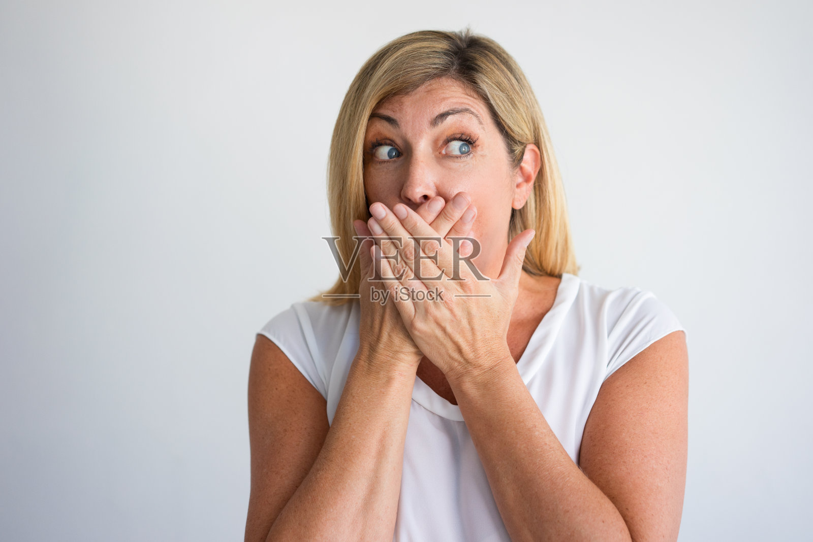 兴奋的中年妇女用手捂住嘴照片摄影图片