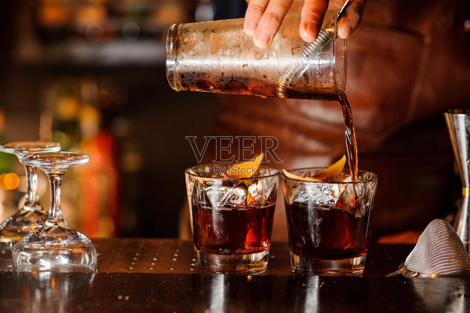 酒保将酒精饮料倒入玻璃杯照片摄影图片