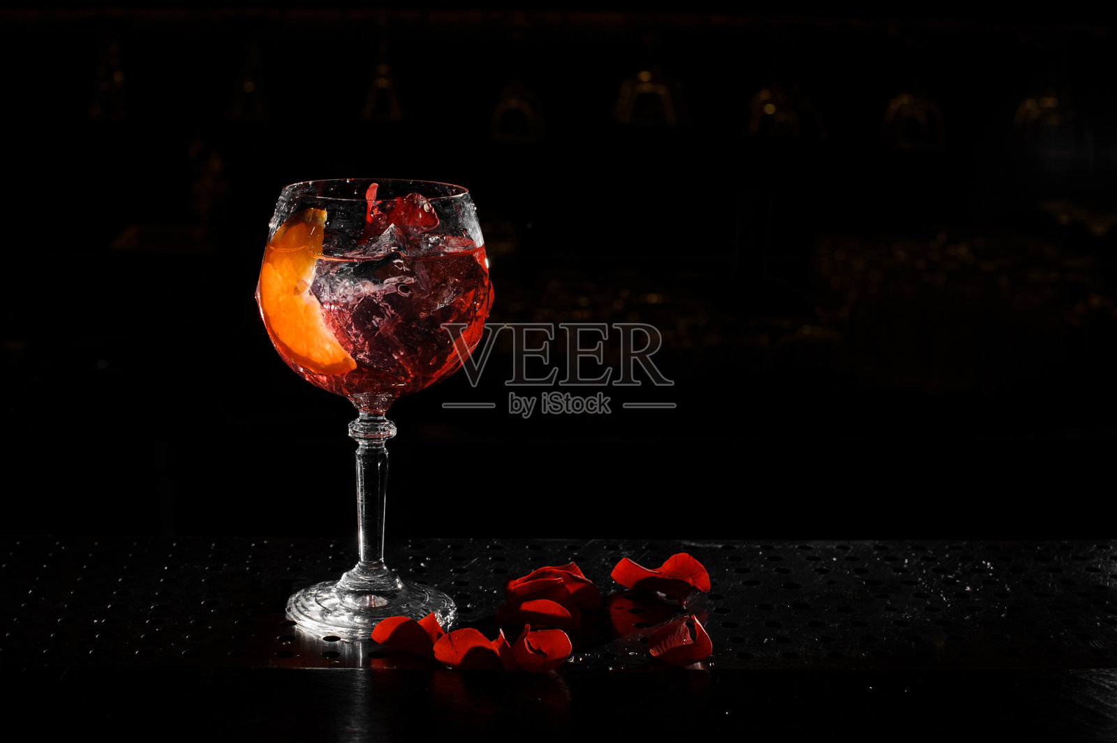 优雅的玻璃上充满新鲜和美味的Aperol注射器夏季鸡尾酒在黑色的背景照片摄影图片