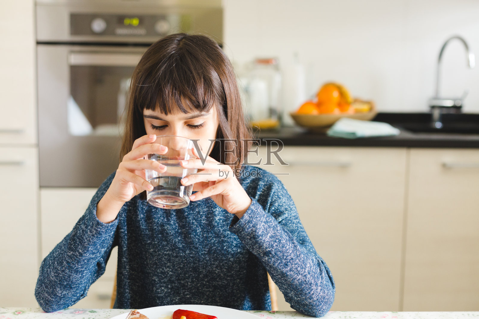可爱的口渴女孩在家里用玻璃杯喝水照片摄影图片