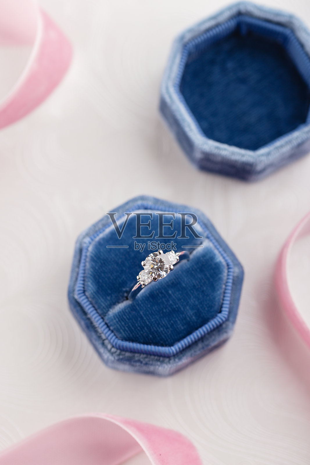 白色黄金结婚戒指与钻石在蓝色复古天鹅绒盒子照片摄影图片