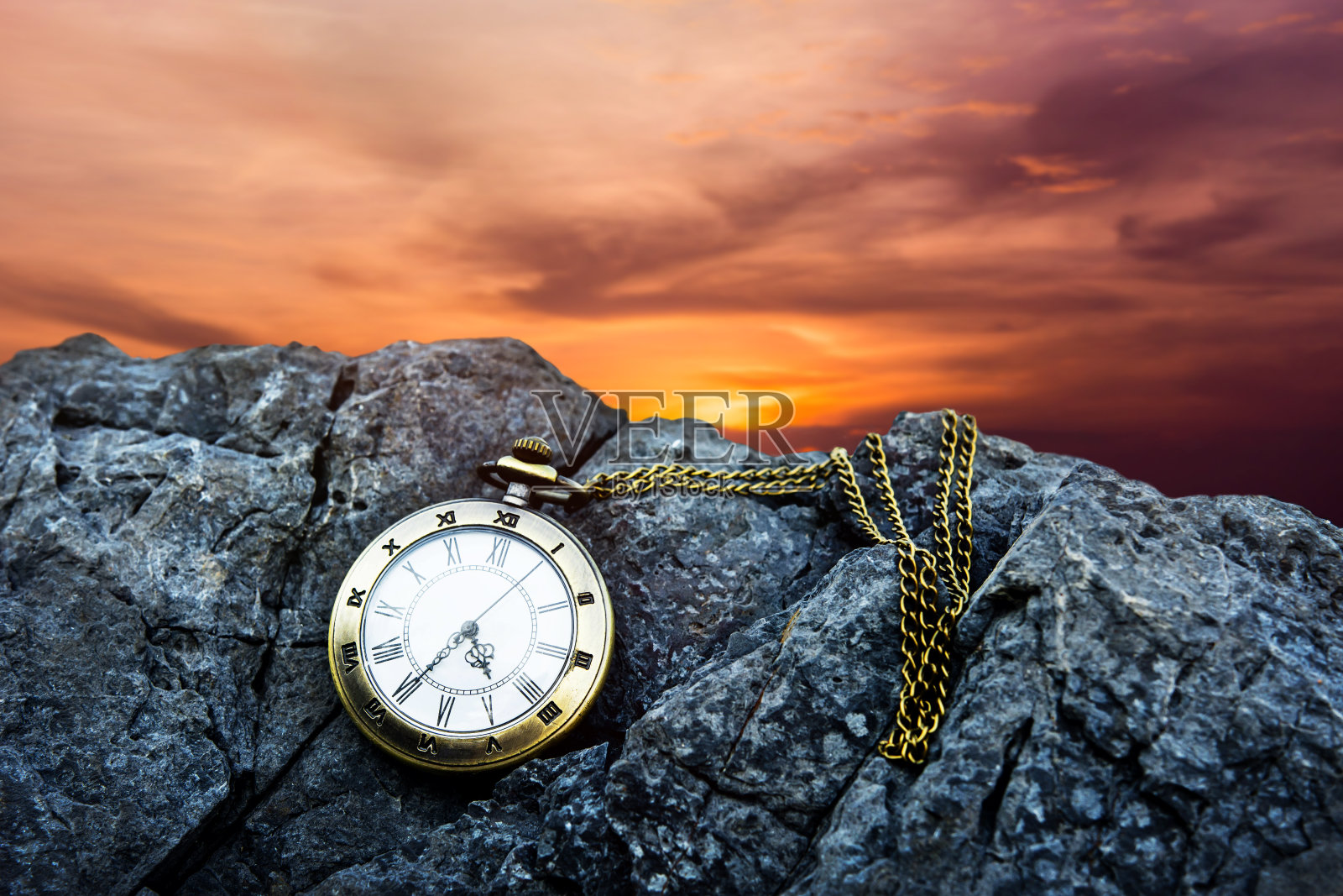 时间的概念。Vintage Golden Pocket Watch on island rock, Sunrise or Sunset Sky as background照片摄影图片