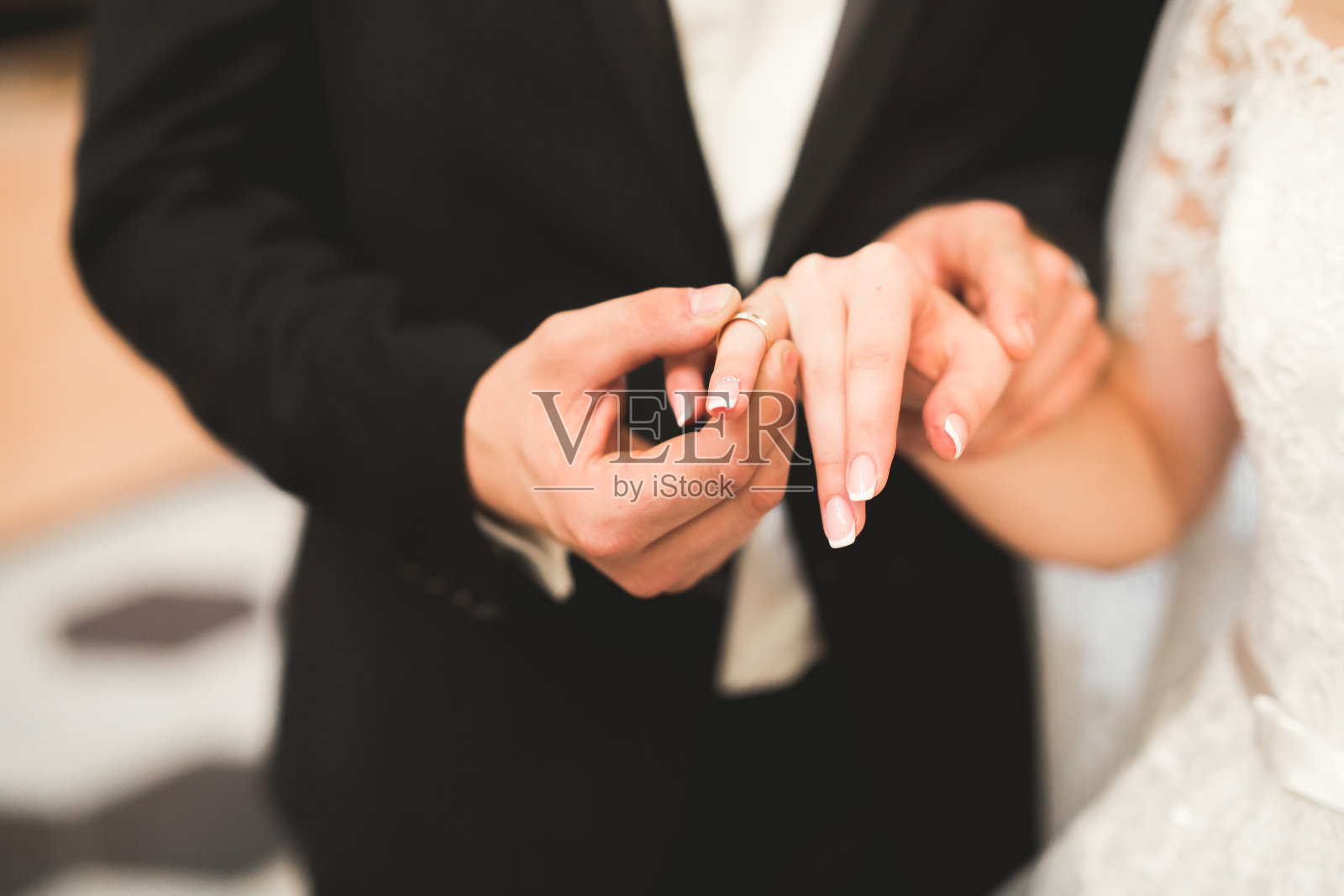 新娘和新郎交换结婚戒指。时尚新人正式典礼照片摄影图片