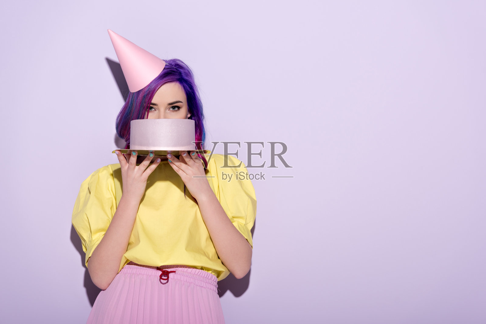 迷人的年轻女子与彩色的头发覆盖脸与生日蛋糕照片摄影图片