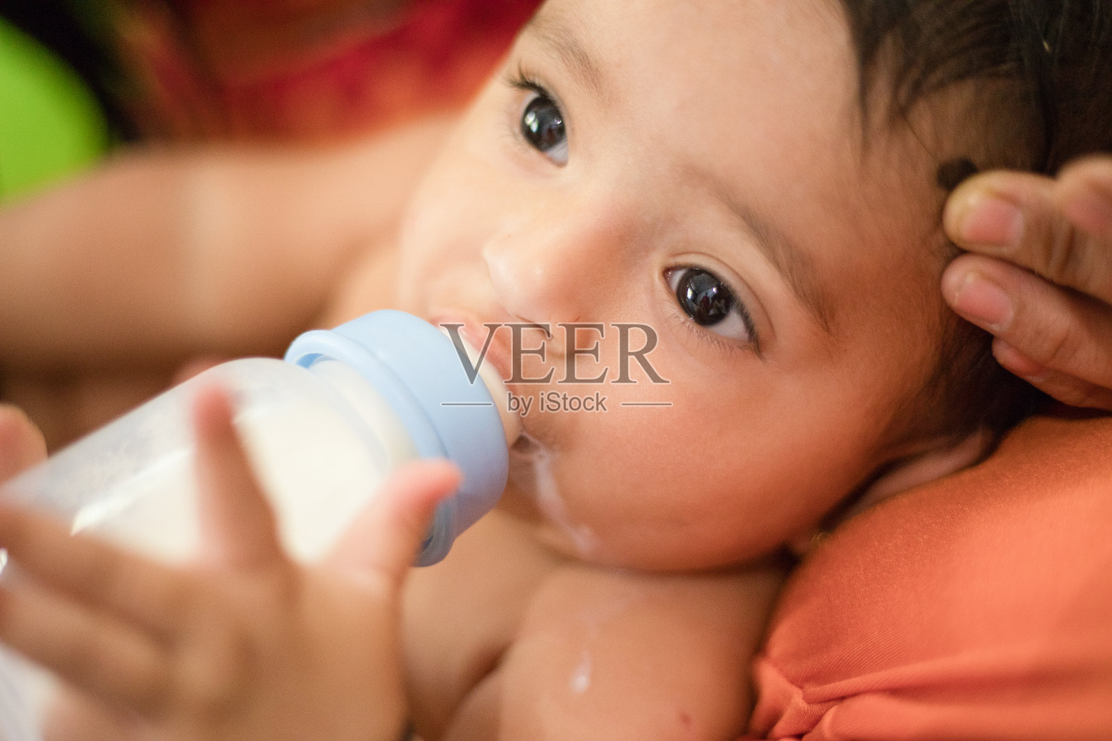 女婴在喝奶瓶里的牛奶照片摄影图片
