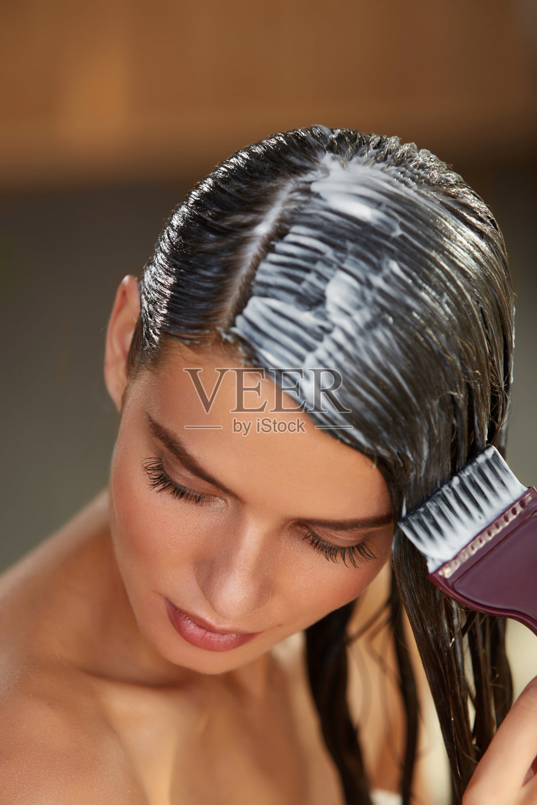 头发的面具。女人用刷子在湿长发上敷面膜照片摄影图片