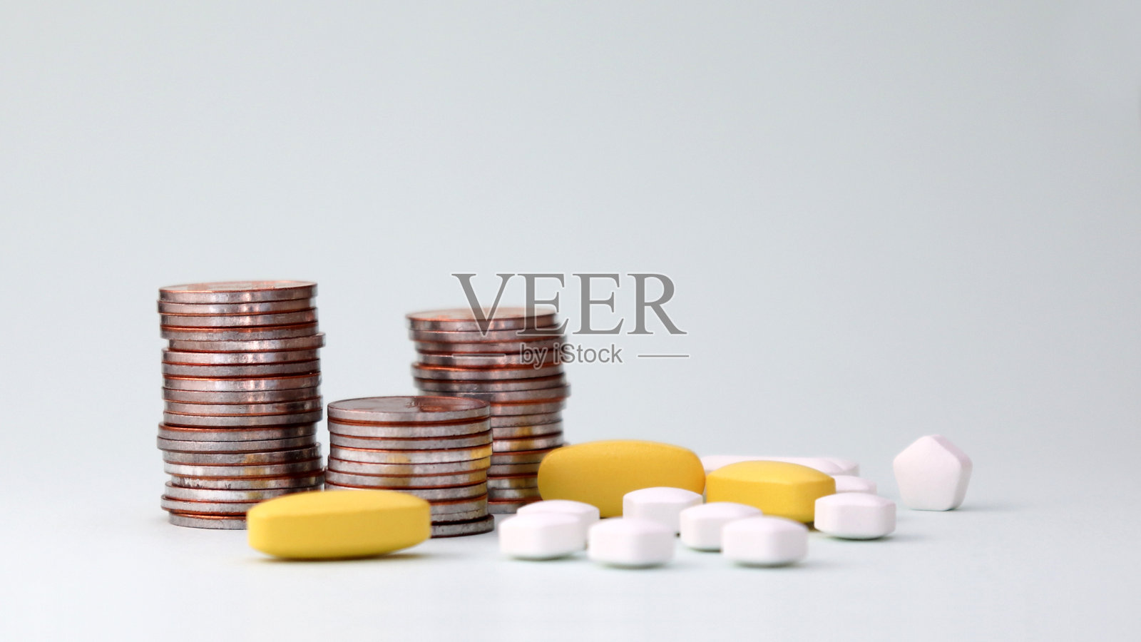 一堆硬币和药丸。医疗成本上升的概念。照片摄影图片