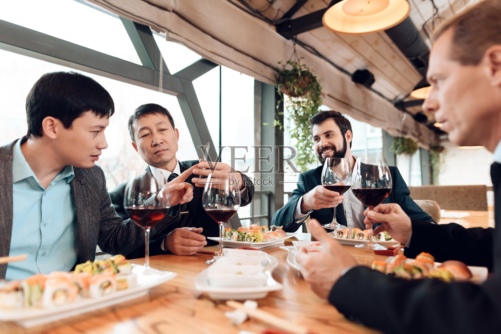 在饭店会见中国商人。男人们在喝酒。照片摄影图片