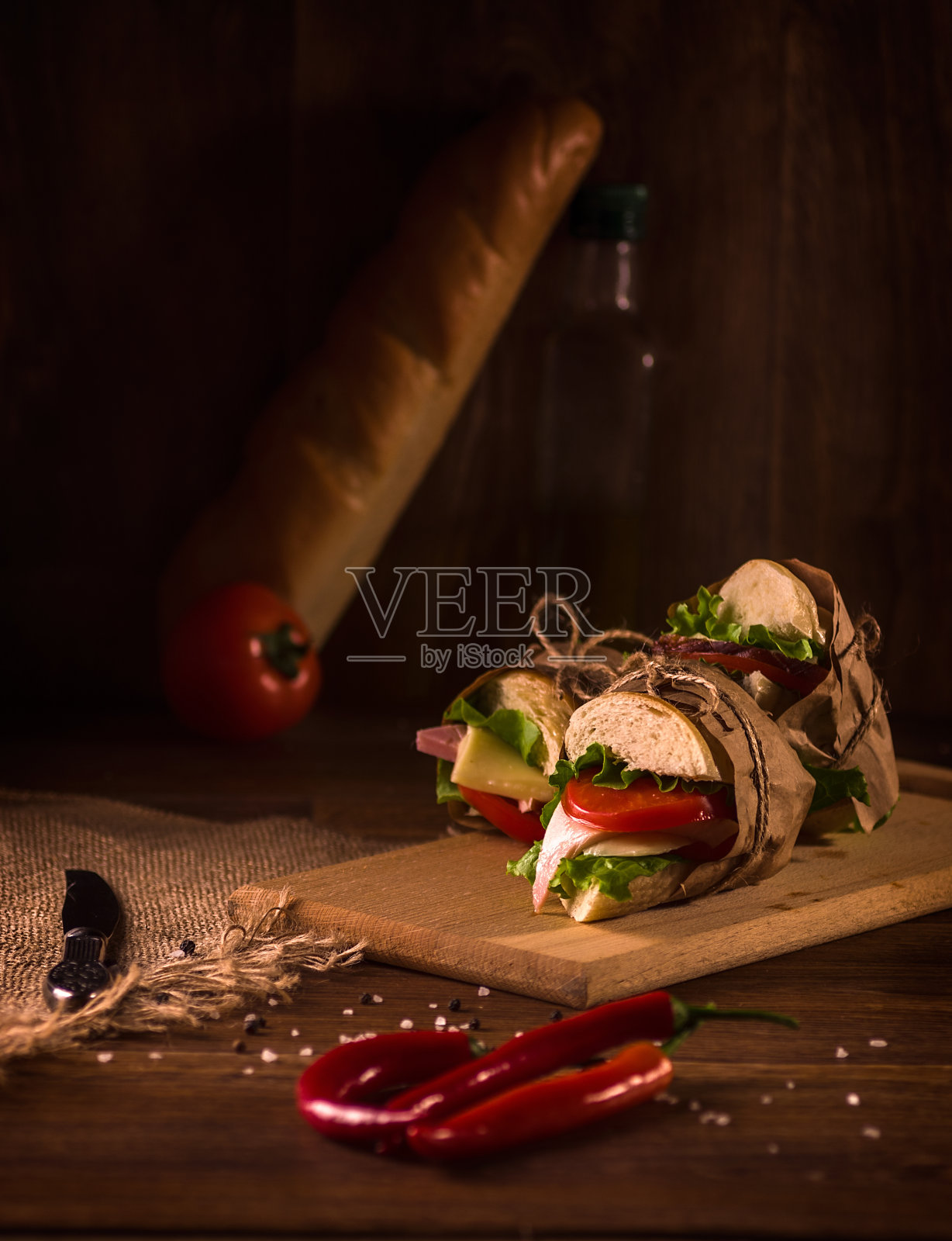夹有火腿、乳酪、番茄、生菜和烤面包的三明治。照片摄影图片