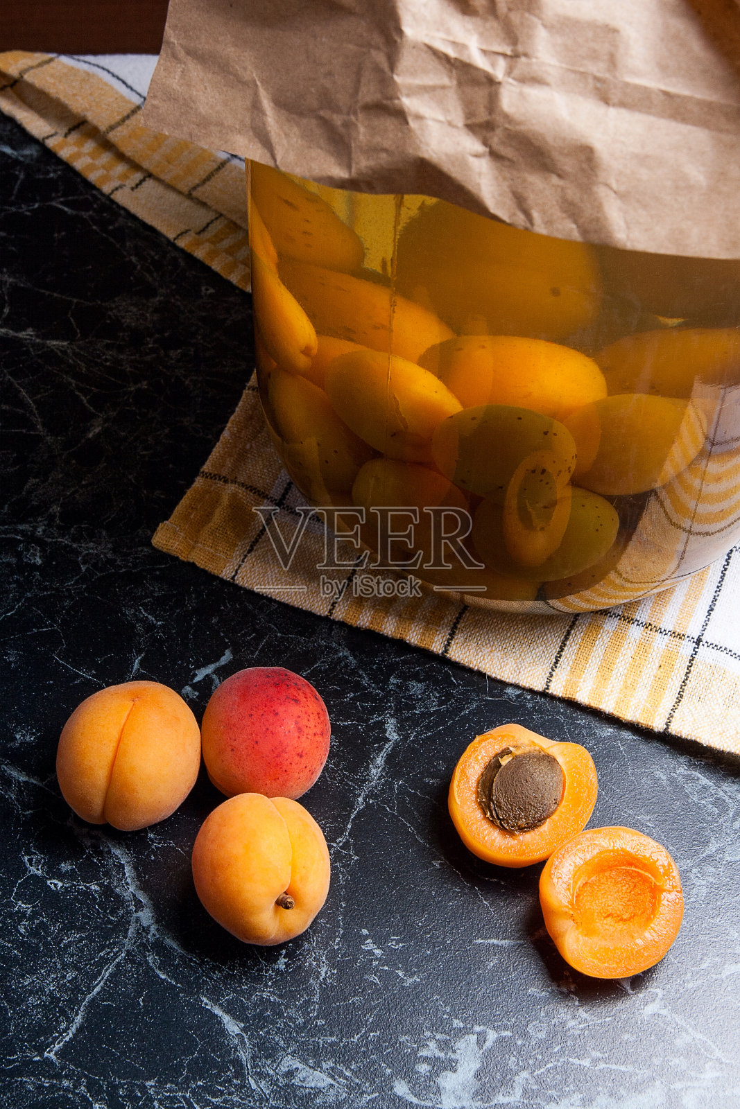 收获的杏和大玻璃罐杏罐头蜜饯照片摄影图片