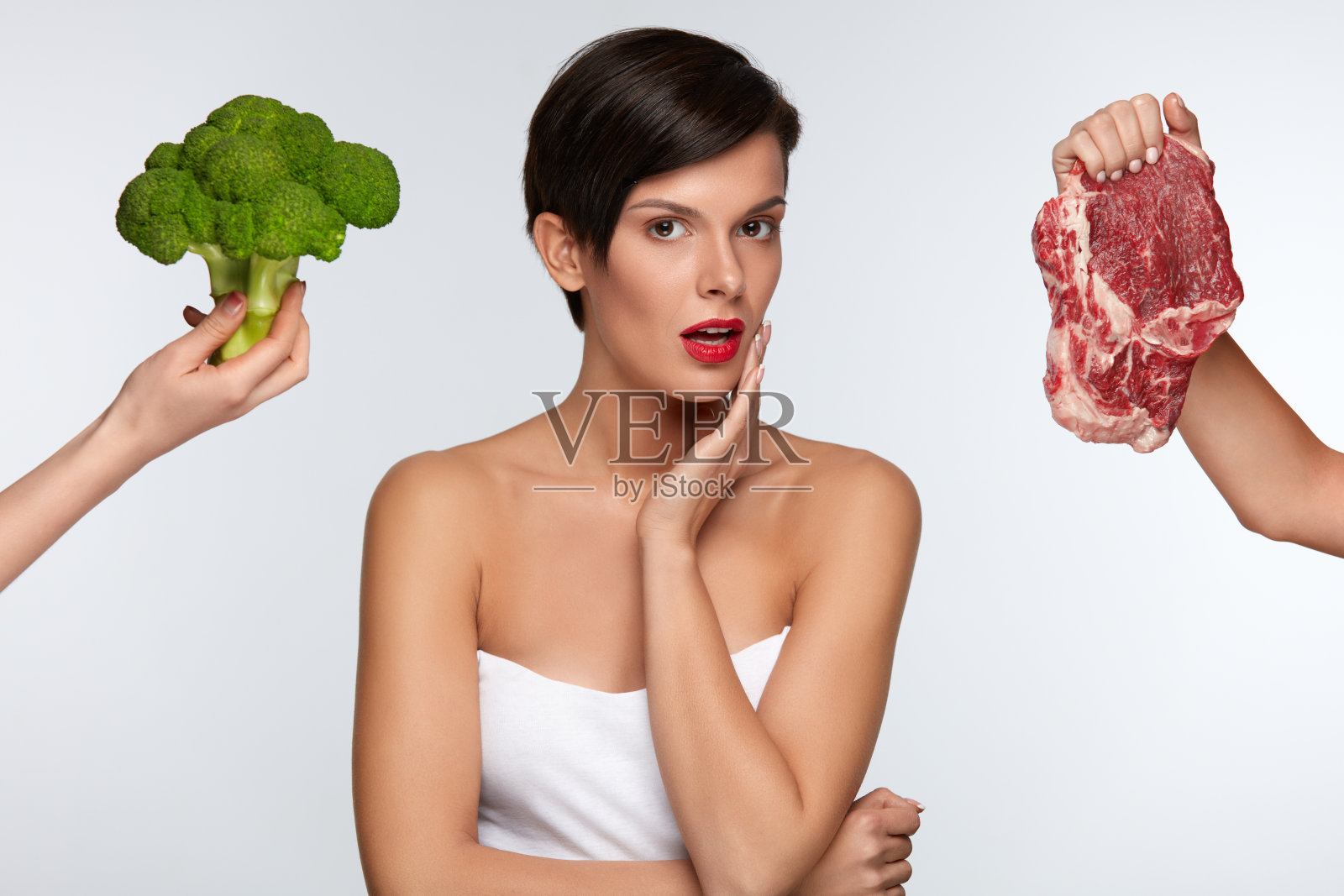 健康美丽的女人在肉和西兰花之间选择照片摄影图片