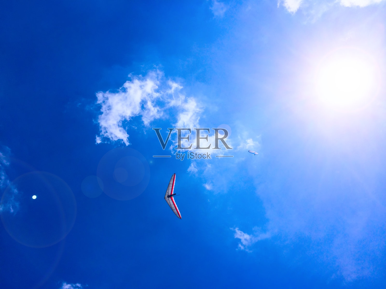 蓝天白云背景下的滑翔伞和悬挂式滑翔伞照片摄影图片