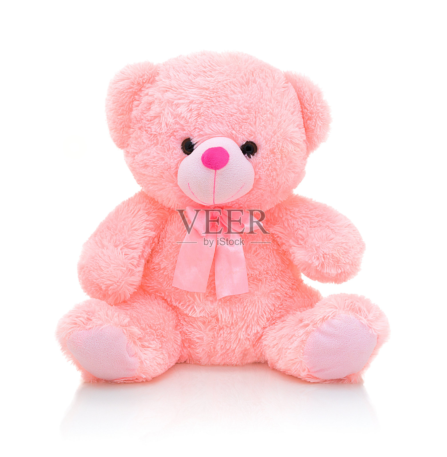 可爱的粉红色熊娃娃与弓孤立在白色背景与阴影反射。顽皮的亮粉色熊坐在白色的衬垫上。泰迪熊毛绒填充木偶与丝带在白色的背景。照片摄影图片