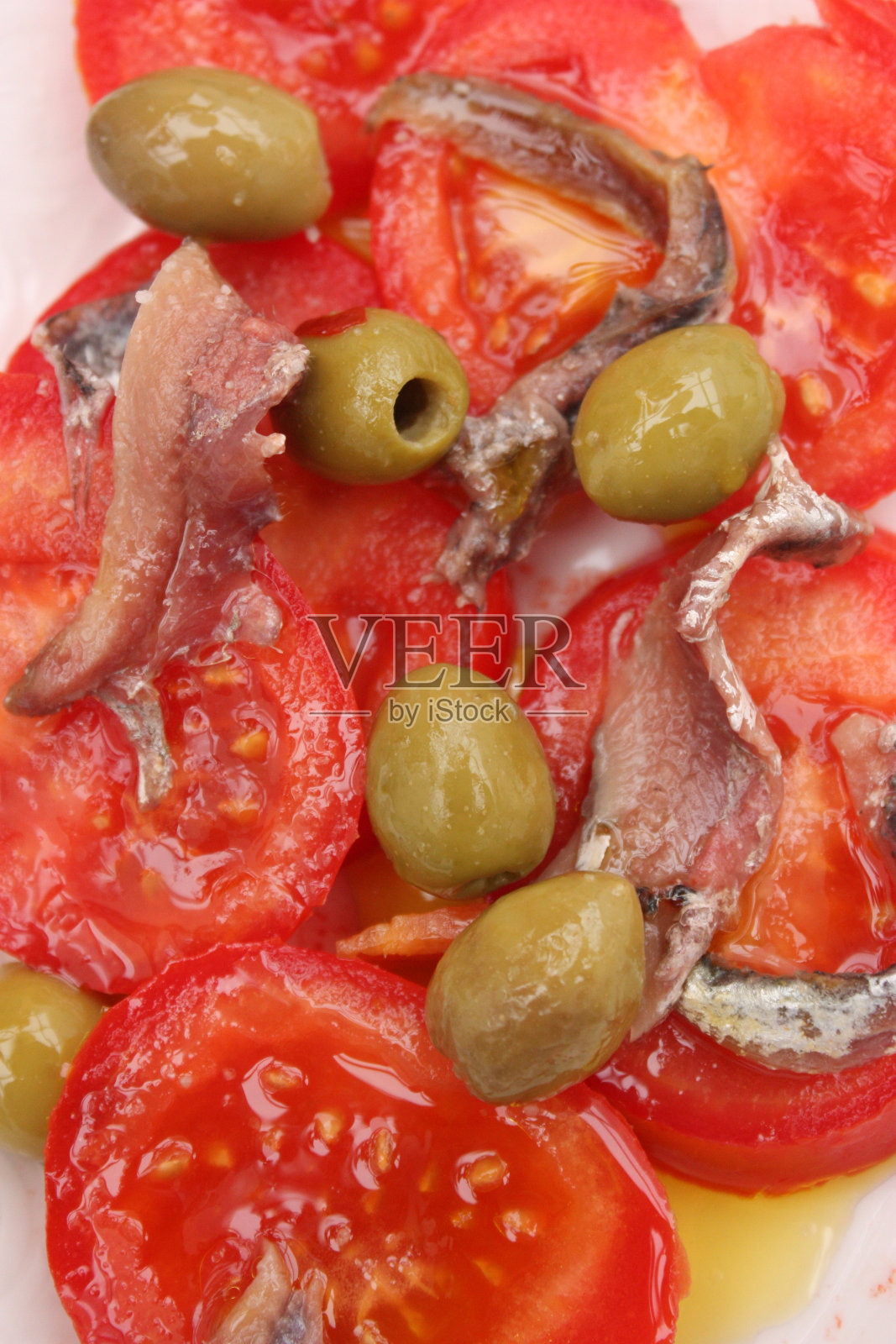 橄榄油拌西红柿和凤尾鱼的沙拉照片摄影图片