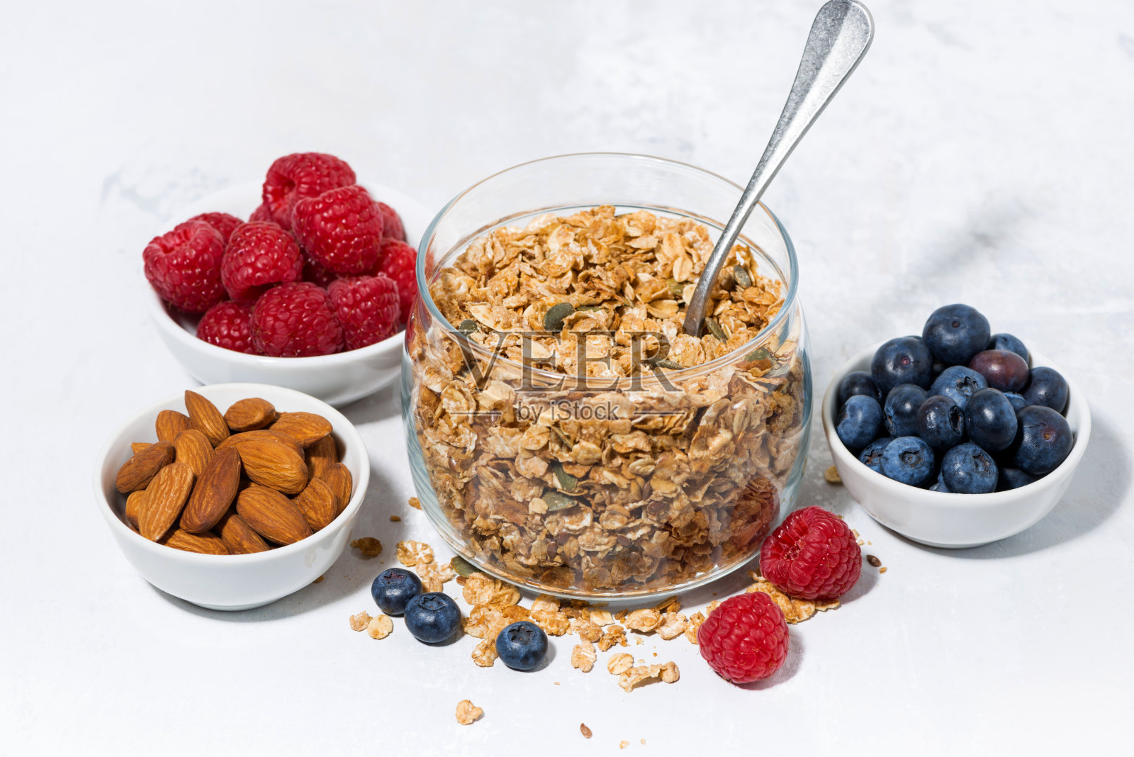 健康的早餐。白色背景上的格兰诺拉麦片和新鲜浆果照片摄影图片