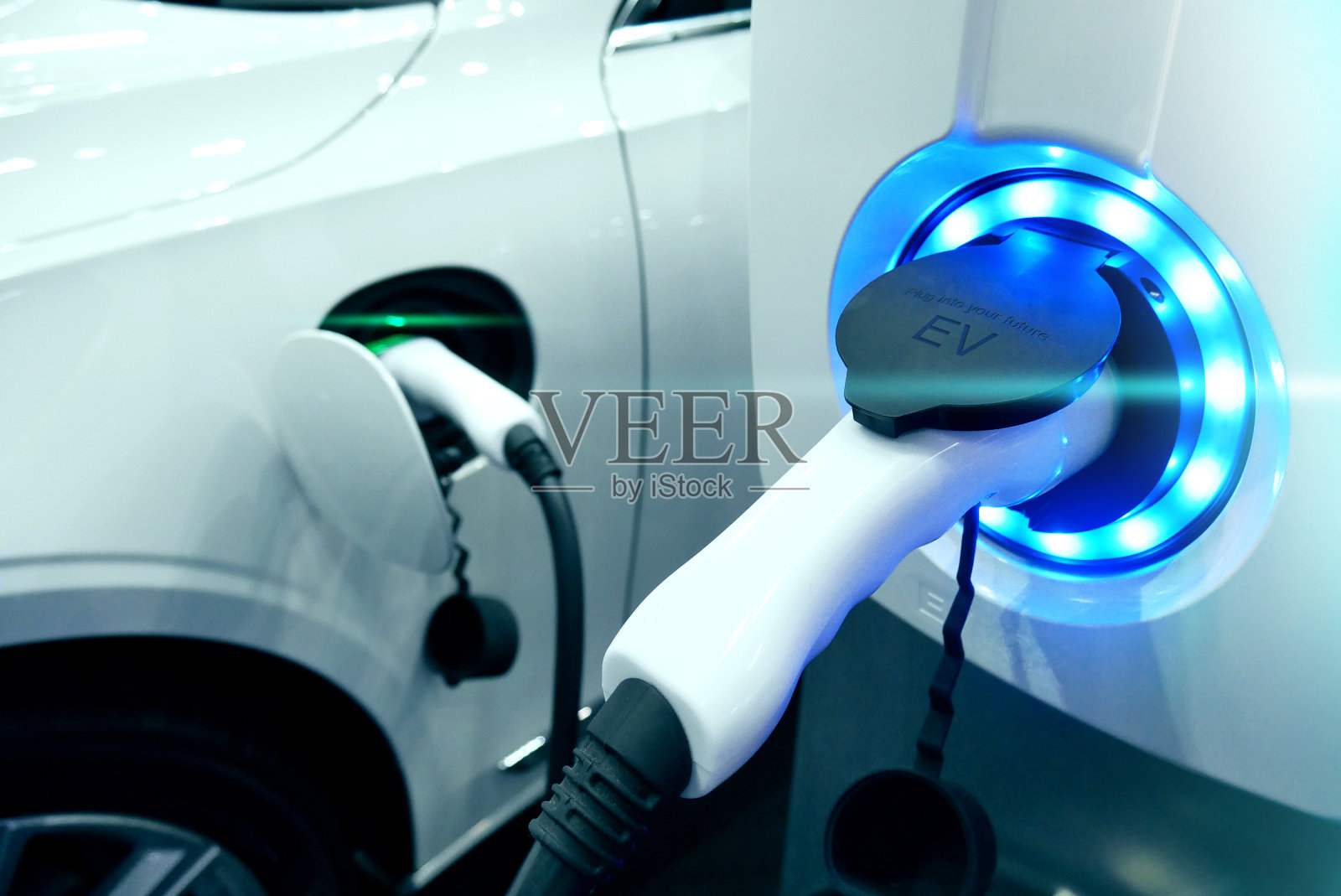 电源连接到电动车，为电池充电。充电技术是未来交通行业的汽车。电动燃料插电式混合动力汽车。照片摄影图片
