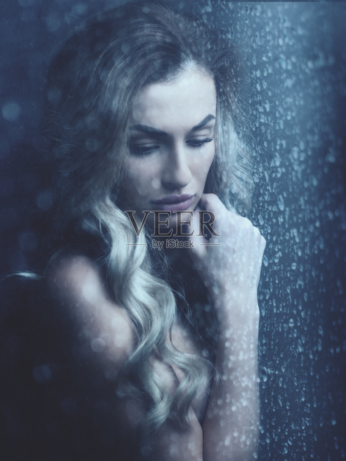 下雨了。女性肖像，美丽的年轻女子在窗户后面与水珠照片摄影图片