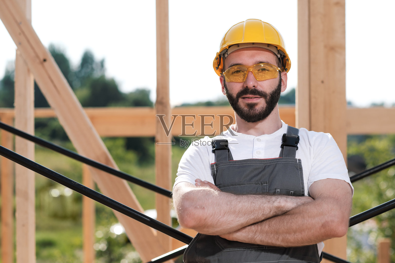 这个人是一个在木框架房子屋顶上的建筑工人照片摄影图片