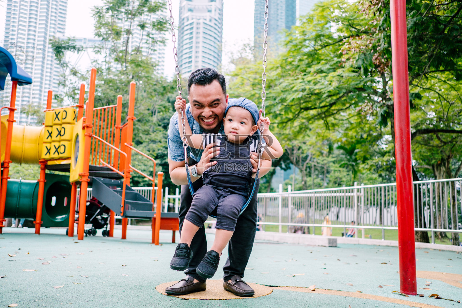 马来西亚父子在公共游乐场玩耍照片摄影图片