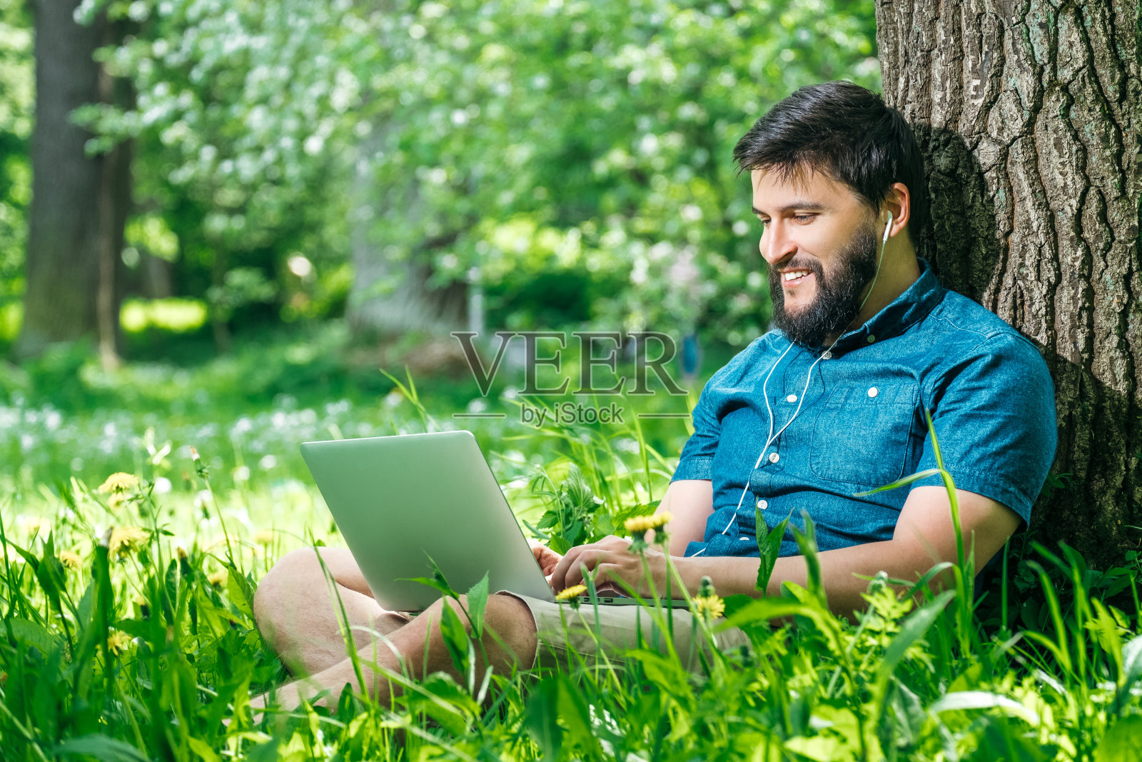 年轻的商人或学生穿着休闲服在公园里使用笔记本电脑。户外办公概念照片摄影图片