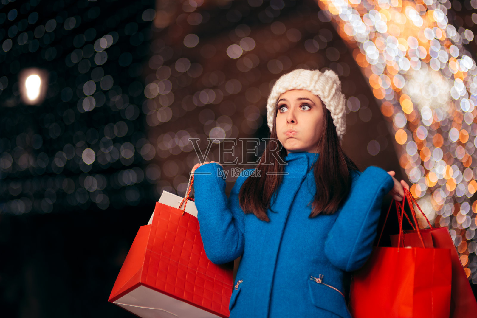 疲惫的女孩拿着购物袋的圣诞灯Décor照片摄影图片