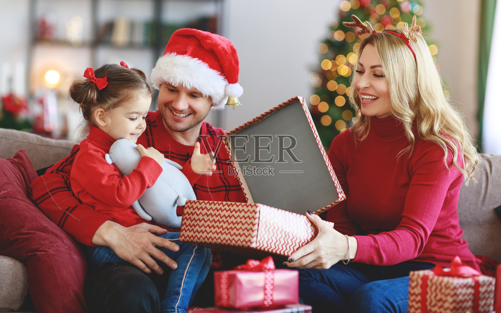 幸福的一家人在圣诞节早晨打开礼物照片摄影图片