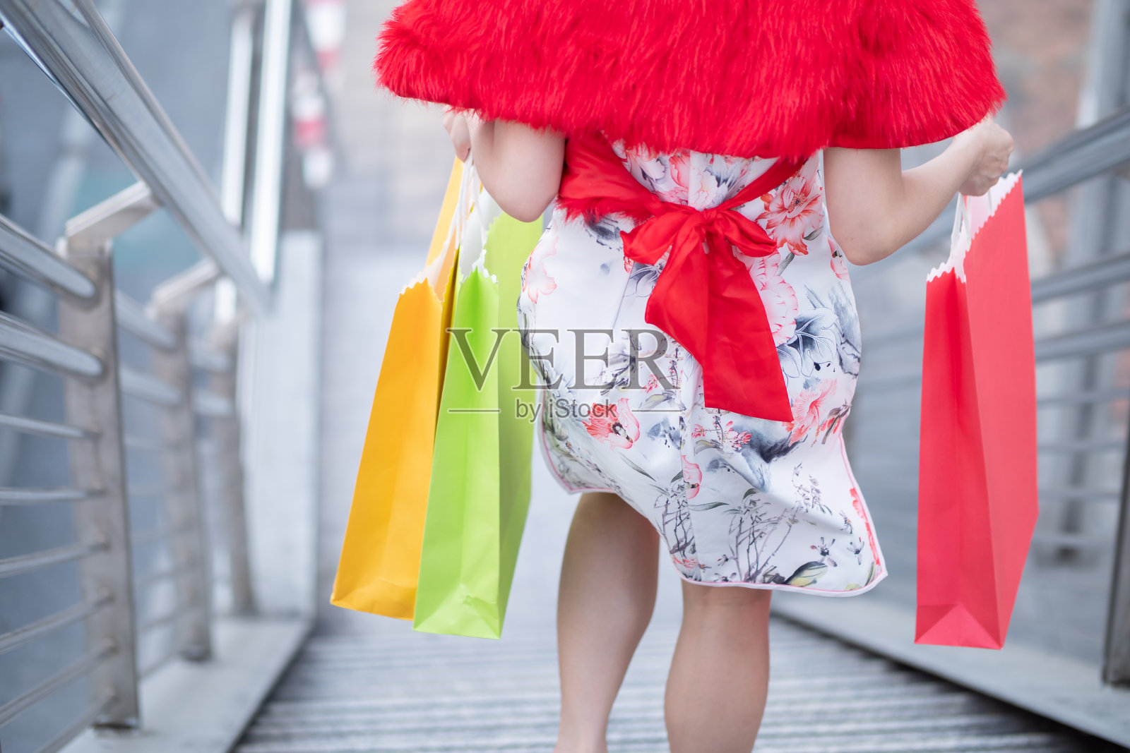 在泰国曼谷市中心，年轻的亚洲女子穿着中式服装，拿着购物袋。中国新年与购物概念照片摄影图片