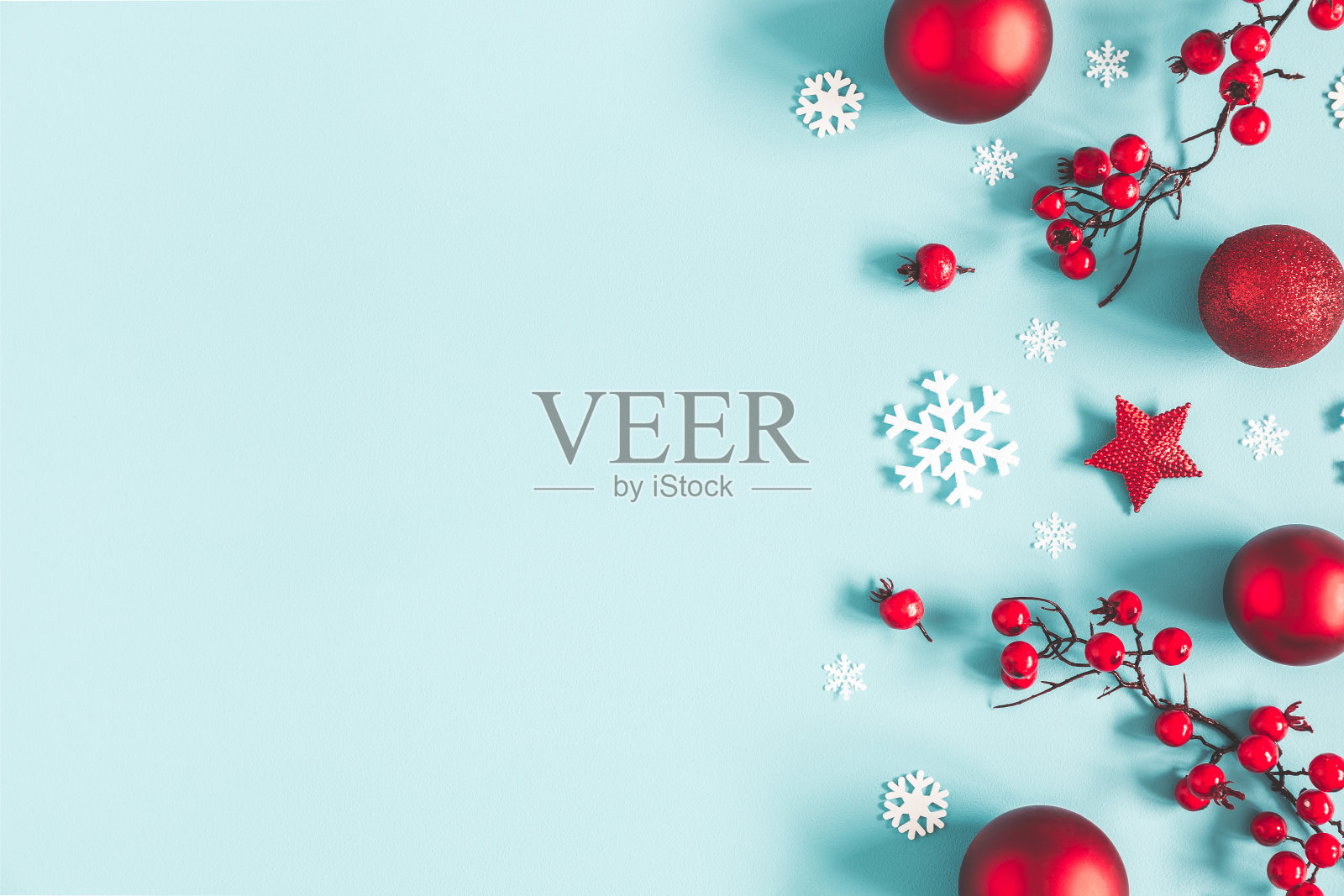 圣诞节或冬天的作文。框架由雪花，球和红色浆果在柔和的蓝色背景。圣诞节，冬天，新年的概念。平铺，俯视图，拷贝空间照片摄影图片