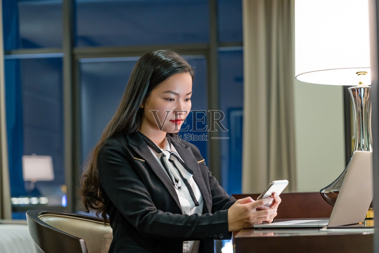 迷人的年轻亚洲商务女性在她的酒店房间工作照片摄影图片