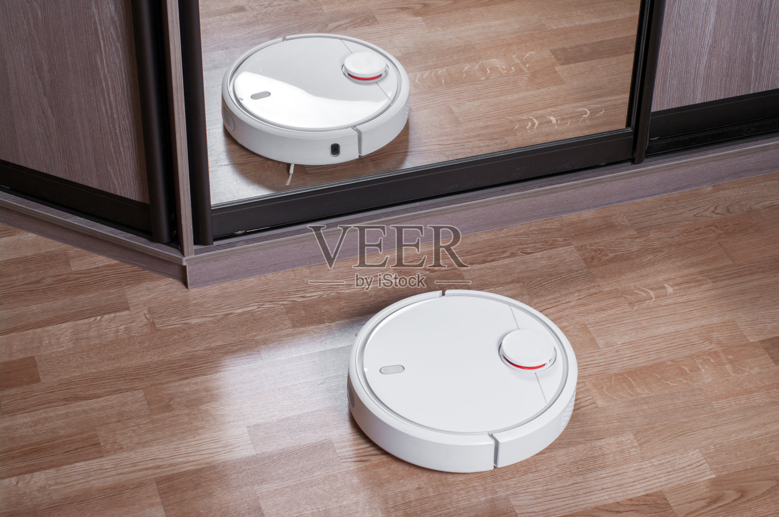强化地板上的吸尘器机器人是衣柜里的镜子，智能家居机器人无线清洁简化了日常家务，有效的吸尘在没有住户照片摄影图片