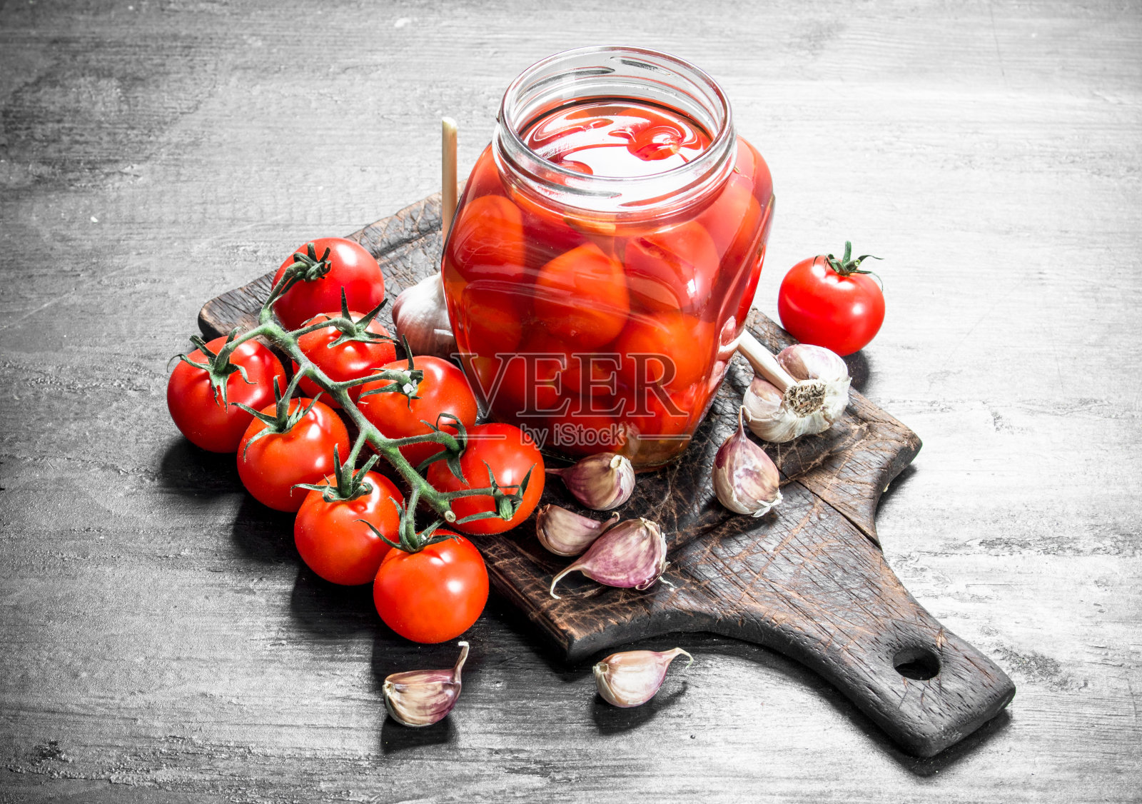 腌番茄配大蒜和香草。照片摄影图片